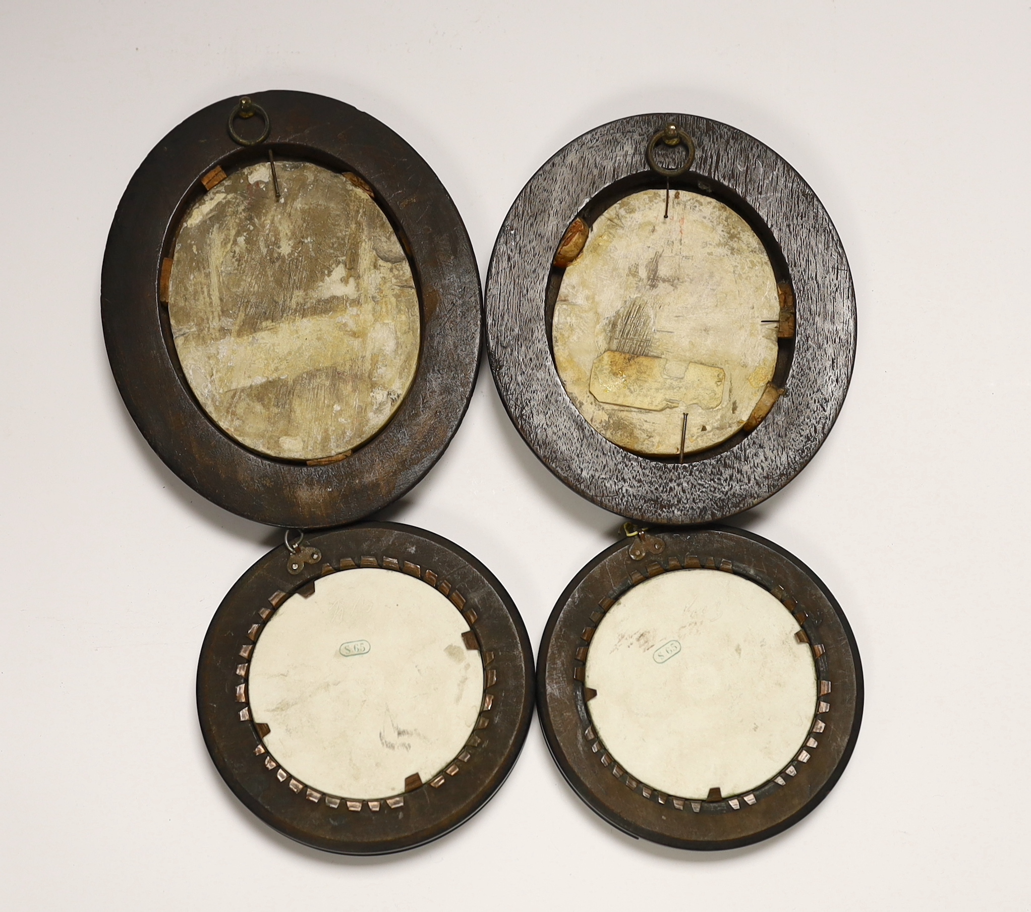A pair of 19th century alabaster relief carved religious plaques and a pair of Sevres biscuit porcelain portrait plaques of Louis Napoleon and Eugene, housed in ebonized frames, largest overall 16cm high